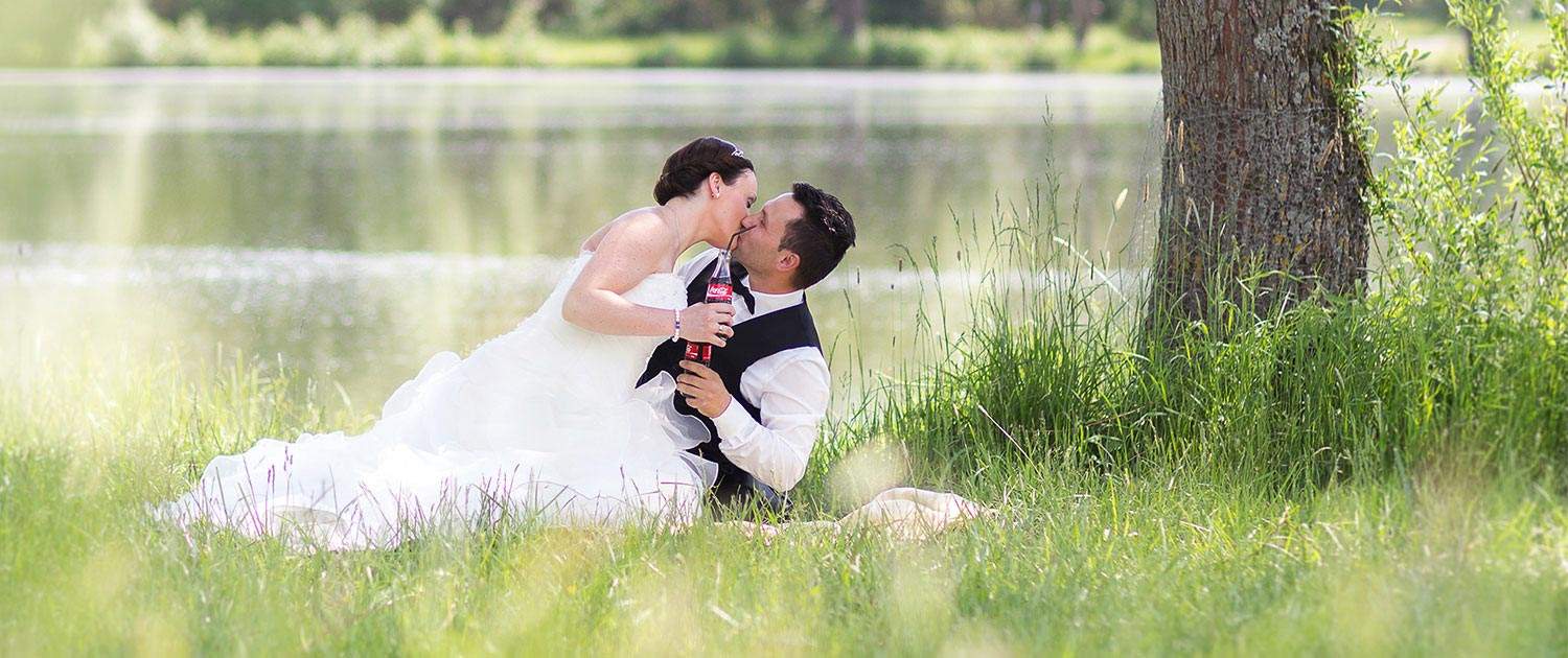 Braut und Bräutigam am See und sich dabei küssen
