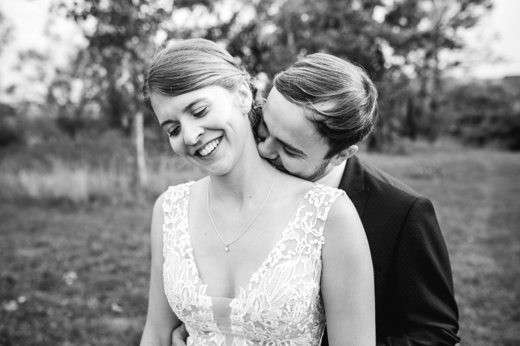Bräutigam küsst seine Braut beim Brautpaarshooting am Hals