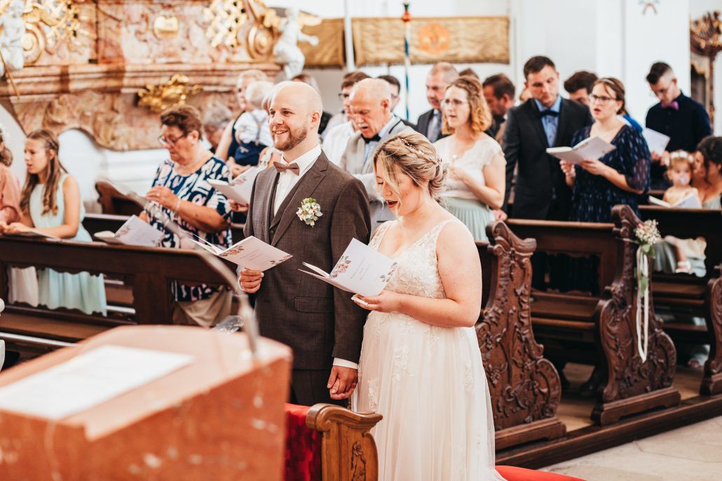 Brautpaar singt währen ihrer kirchlichen Trauung