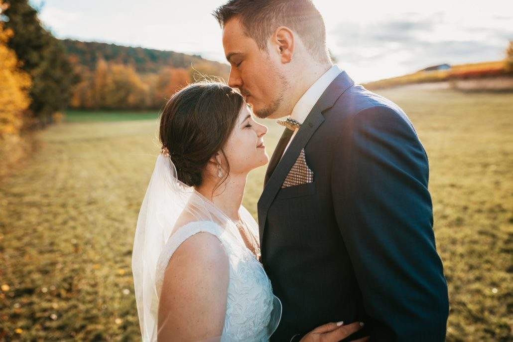 Bräutigam gibt seiner Braut einen Kuss auf die Stirn beim After-Wedding-Shooting eine Woche nach der Hochzeit