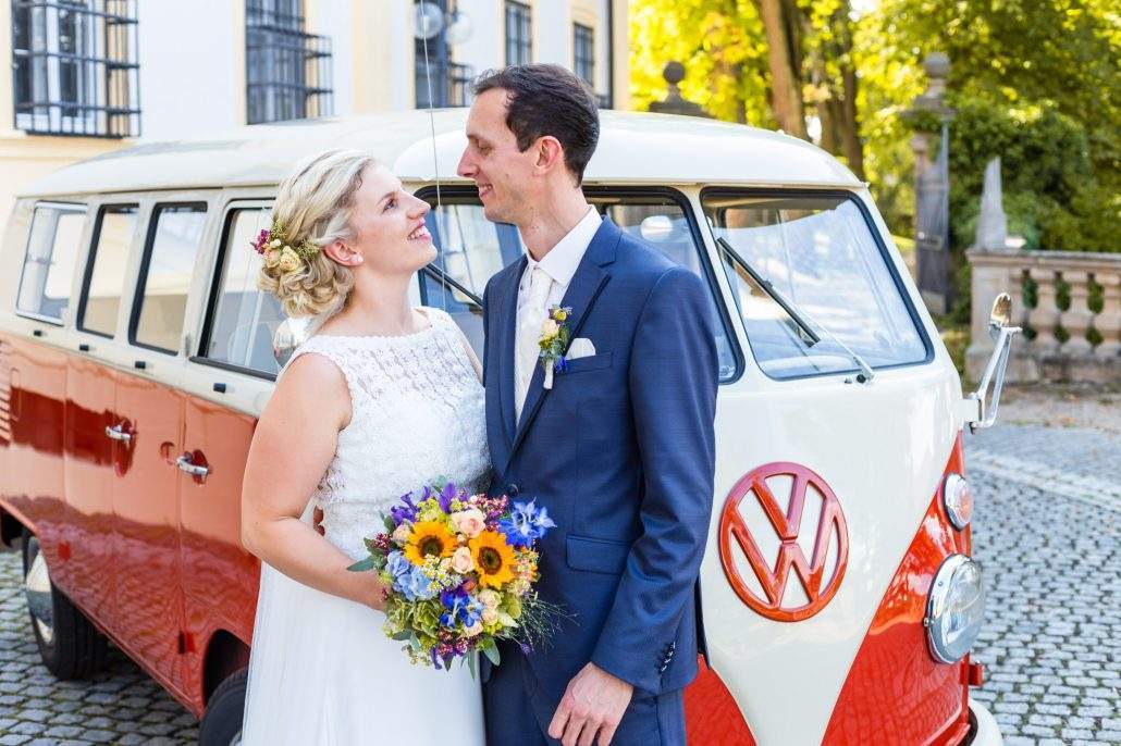 Brautpaar steht vor einen VW Bulli T1 am Schloss Oberschwappach bei Haßfurt