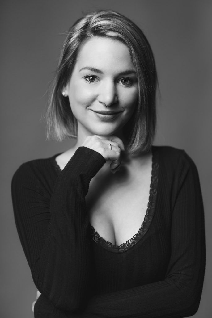 Portrait in schwarz weiß einer jungen Frau im Studio mit Ring und Nasenpiercing