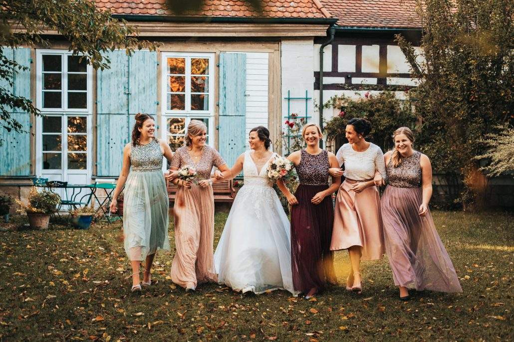 Braut und ihre Brautjungfern scherzen beim Fotoshooting