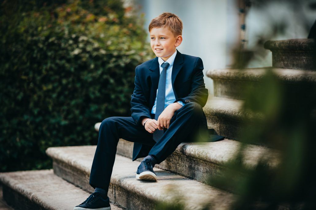 Portrait von einen Jungen im Anzug sitzt auf einer Treppe
